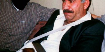 FILE - In this  Monday Feb. 15, 1999 file photo  provided by the Turkish Intelligence Service o the chief of the Kurdistan Workers Party, PKK, Abdullah Ocalan sits guarded aboard an aircraft en route to Turkey following his arrest by Turkish special forces in Nairobi, Kenya. Imprisoned Kurdish rebel leader Abdullah Ocalan said Monday, March 18, 2013 that peace talks with Turkey are making "positive progress" and that he plans to make a "historic" announcement to coincide with a Kurdish spring festival. (AP Photo/Turkish Intelligence Service, File)