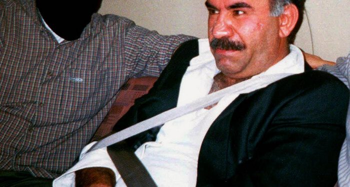 FILE - In this  Monday Feb. 15, 1999 file photo  provided by the Turkish Intelligence Service o the chief of the Kurdistan Workers Party, PKK, Abdullah Ocalan sits guarded aboard an aircraft en route to Turkey following his arrest by Turkish special forces in Nairobi, Kenya. Imprisoned Kurdish rebel leader Abdullah Ocalan said Monday, March 18, 2013 that peace talks with Turkey are making "positive progress" and that he plans to make a "historic" announcement to coincide with a Kurdish spring festival. (AP Photo/Turkish Intelligence Service, File)