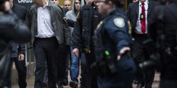 Martin Shkreli, chief executive officer of Turing Pharmaceuticals LLC, center, and attorney Evan Greebel, left, exit federal court in New York, U.S., on Thursday, Dec. 17, 2015. Shkreli was arrested on alleged securities fraud related to Retrophin Inc., a biotech firm he founded in 2011. Greebel is accused of conspiring with Shkreli in part of the scheme. Photographer: John Taggart/Bloomberg *** Local Caption *** Martin Shkreli; Evan Greebel