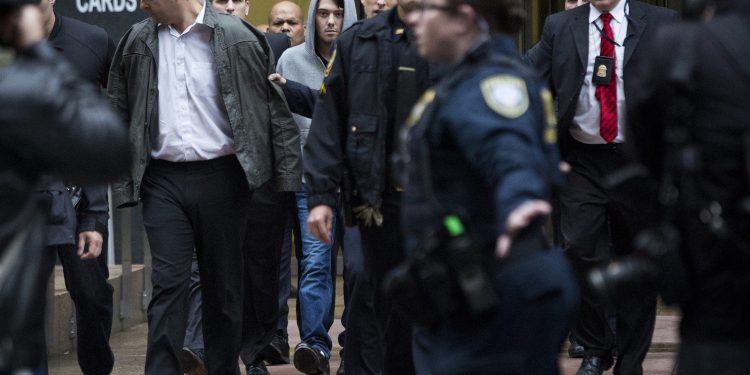 Martin Shkreli, chief executive officer of Turing Pharmaceuticals LLC, center, and attorney Evan Greebel, left, exit federal court in New York, U.S., on Thursday, Dec. 17, 2015. Shkreli was arrested on alleged securities fraud related to Retrophin Inc., a biotech firm he founded in 2011. Greebel is accused of conspiring with Shkreli in part of the scheme. Photographer: John Taggart/Bloomberg *** Local Caption *** Martin Shkreli; Evan Greebel