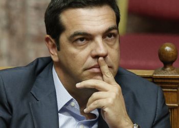Greek Prime Minister Alexis Tsipras attends a parliamentary session in Athens, Friday, Aug. 14, 2015. Greek lawmakers are continuing a debate in parliament to approve a massive new bailout deal after repeated delays over procedure and dissent within the governing left-wing Syriza party caused the session to last through the night. (AP Photo/Yannis Liakos)