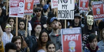 People hold signs as they listen to speakers at a protest against the election of President-elect Donald Trump, Wednesday, Nov. 9, 2016, in downtown Seattle. (AP Photo/Ted S. Warren)
