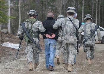 Alaska National Guard Soldiers escort a protestor away after assisting Anchorage Police to calm or detain rioters as part of the training scenario of exercise Vigilant Guard Ft. Richardson, Alaska, Wednesday April 28, 2010. Vigilant Guard is an annual, disaster-based training scenario that tests the coordination of National Guard units with local, state, regional, and national disaster preparedness organizations. (U.S. Air Force photo by Tech. Sgt. Brian E. Christiansen, North Carolina National Guard) (Released)