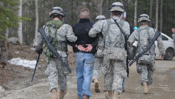 Alaska National Guard Soldiers escort a protestor away after assisting Anchorage Police to calm or detain rioters as part of the training scenario of exercise Vigilant Guard Ft. Richardson, Alaska, Wednesday April 28, 2010. Vigilant Guard is an annual, disaster-based training scenario that tests the coordination of National Guard units with local, state, regional, and national disaster preparedness organizations. (U.S. Air Force photo by Tech. Sgt. Brian E. Christiansen, North Carolina National Guard) (Released)