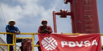 Workers stand in front of a drilling rig at an oil well operated by Venezuela's state oil company PDVSA in Morichal July 28, 2011.  Venezuela received an enviable honor last month: OPEC said it is sitting on the biggest reserves of crude oil in the world -- even more than Saudi Arabia.  But the Venezuelan oil industry is also sitting atop a well of trouble.  Picture taken July 28, 2011.  To match Special Report VENEZUELA/PDVSA  REUTERS/Carlos Garcia Rawlins (VENEZUELA - Tags: ENERGY POLITICS BUSINESS)