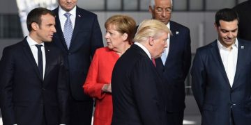French President Emmanuel Macron (L) and German Chancellor Angela Merkel (2nd L) speaks as US President Donald Trump (C) arrives next to Greek Prime Minister Alexis Tsipras (R) for a family picture during the NATO (North Atlantic Treaty Organization) summit at the NATO headquarters, in Brussels, on May 25, 2017. / AFP PHOTO / Eric FEFERBERG        (Photo credit should read ERIC FEFERBERG/AFP/Getty Images)