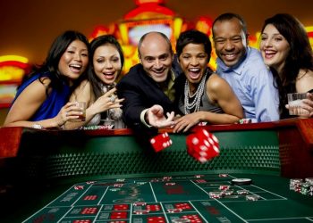 Excited friends gambling at craps table in casino