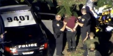 A man placed in handcuffs is led by police near Marjory Stoneman Douglas High School following a shooting incident in Parkland, Florida, U.S. February 14, 2018 in a still image from video.  WSVN.com via REUTERS. ATTENTION EDITORS - THIS IMAGES HAS BEEN PROVIDED BY A THIRD PARTY. NO RESALES, NO ARCHIVES. MANDATORY CREDIT. NO ACCESS SOUTHEAST FLORIDA MEDIA.