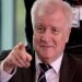 German Interior Minister Horst Seehofer points prior to the weekly cabinet meeting at the chancellery in Berlin, Germany, Friday, July 6, 2018. (AP Photo/Michael Sohn)