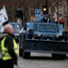 Protesters wearing yellow vests walk near armoured gendarmerie vehicles as they arrive to attend a demonstration by the "yellow vests" movement in Paris, France, December 8, 2018. REUTERS/Benoit Tessier