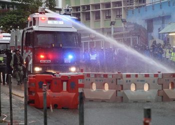 epaselect epa07792203 An anti-riot police vehicle equipped with a water cannon clears the road from a barricade set up by protesters during an anti-government rally in Kwai Fung and Tsuen Wan, Hong Kong, China, 25 August 2019. The protests were triggered last June by an extradition bill to China, now suspended, and evolved into a wider anti-government movement with no end in sight.  EPA/JEROME FAVRE