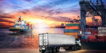 Logistics import export background and transport industry of Container truck and Cargo ship with working crane bridge in shipyard at sunset sky