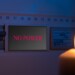 Electrical switch box panel with the text "no power" and burning candle in hand Concept of "green energy" crisis in Europe