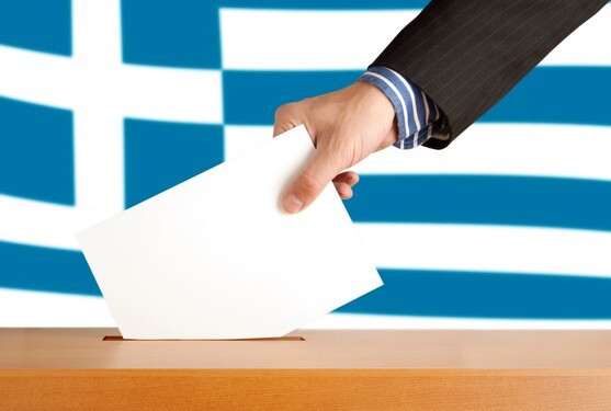 Hand with ballot and box on Flag of Greece