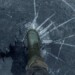 Fisherman foot on broken cracked thin ice at lake. Dangerous fishing