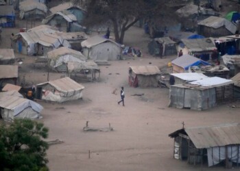 FILE - People stand by their houses in Juba, South Sudan, on Feb. 5, 2023. South Sudan’s government is closing down all schools starting Monday as the country prepares for a wave of extreme heat expected to last two weeks. The health and education ministries advised parents to keep all children indoors as temperatures are expected to soar to 113 Fahrenheit, in a statement late Saturday. (AP Photo/Gregorio Borgia, File)