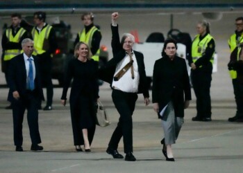 WikiLeaks founder Julian Assange gestures after landing at RAAF air base Fairbairn in Canberra, Australia, Wednesday, June 26 2024. Assange has returned to his homeland Australia aboard a charter jet hours after pleading guilty to obtaining and publishing U.S. military secrets in a deal with Justice Department prosecutors that concludes a drawn-out legal saga.(AP Photo/Rick Rycroft)