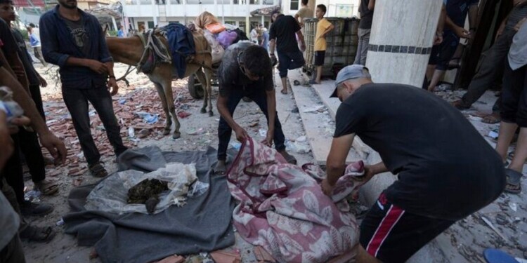 Palestinians search for bodies in the rubble of a school destroyed in an Israeli airstrike on Deir al-Balah, central Gaza Strip, Saturday, July 27, 2024. (AP Photo/Abdel Kareem Hana)