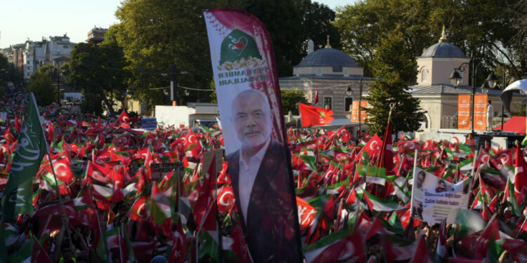 A picture of Hamas leader Ismail Haniyeh, who was killed in Tehran is carried amid of demonstrators waving Palestinian and Turkish flags during a rally in support of Palestinians in Gaza, in Istanbul, Turkey, Saturday, Aug. 3, 2024. (AP Photo/Khalil Hamra)