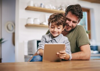 Shot of a single father sitting with his son while using a digital tablet