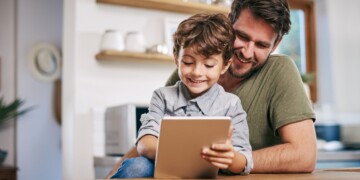 Shot of a single father sitting with his son while using a digital tablet