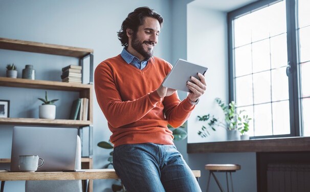 Businessman leaning on the table and working on digital tablet.