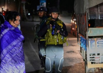 An Indian army officer stands guard as tourists look on at a temporary checkpoint near Pahalgam in south Kashmir after assailants indiscriminately opened fire on tourists visiting Pahalgam, Indian controlled Kashmir, Tuesday, April 22, 2025. (AP Photo/Dar Yasin)