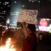 A protester stands beside a bonfire at a demonstration against Israeli Prime Minister Benjamin Netanyahu's government as protesters call for the release of hostages held in the Gaza Strip by the Hamas militant group in Tel Aviv, Israel, Saturday, June 1, 2024. (AP Photo/Maya Alleruzzo)