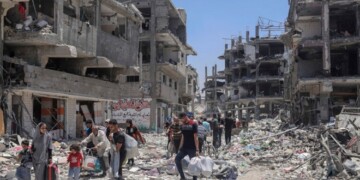 FILE - Palestinians walk through the destruction in the wake of an Israeli air and ground offensive in Jebaliya, northern Gaza Strip, on May 30, 2024. (AP Photo/Enas Rami, File)