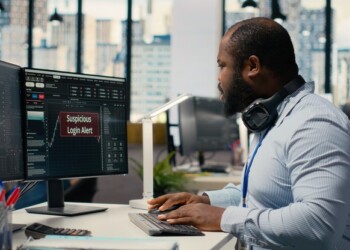 Forex investment consultant investigating suspicious access on trading account. African american man in office worried about security popup on PC about attempted breach of client account