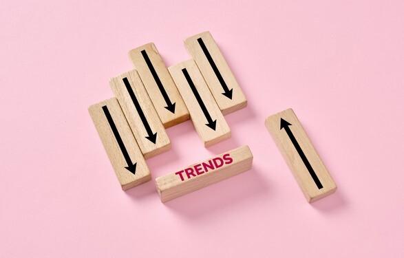 Wooden blocks displaying a concept of marketing trends changing direction, with most blocks moving down and one moving up
