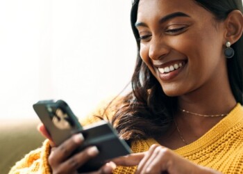 Happy, woman and phone for online shopping with credit card information, fintech website and digital payment in lounge. Smile, female person and e commerce, retail discount and banking app at house.